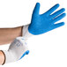 A person wearing Cordova Cor-Grip gray gloves with blue crinkle latex palm coating.