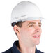 A man wearing a white Cordova hard hat with a ratchet suspension smiles for the camera.