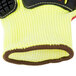 A close-up of a yellow and black Cordova cut resistant glove with a red sandy nitrile palm coating and TPR reinforcements.