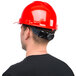 A man wearing a Cordova red cap style hard hat.