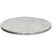A Tablecraft round aluminum table cover with a random swirl pattern on a round white table top with a silver edge.