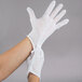 A person's hand wearing a pair of white Cordova inspection gloves.