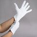 A pair of hands wearing white Cordova reversible lisle gloves.