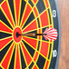 A red and white Arachnid soft tip dart in the center of a dart board.