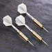 Three Unicorn checkered steel tip darts with gold tips on a table.