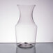 A clear plastic wine carafe on a table.