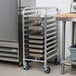 A Regency aluminum steam table pan rack with trays on it.