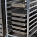 An unassembled Regency aluminum steam table pan rack holding 10 pans.