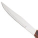 A Walco stainless steel steak knife with a brown Pakka wood handle.