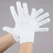 A close up of a hand wearing a Cordova white work glove.