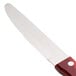 A Walco stainless steel steak knife with a Jumbo Brazil Polywood handle in red.