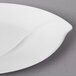 A close-up of a white Villeroy & Boch porcelain oval platter with a curved edge.