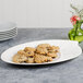 A Villeroy & Boch white porcelain oval platter filled with cookies on a table.