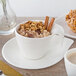 A white Villeroy & Boch porcelain saucer with a cup of oatmeal and cinnamon sticks.