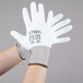 A pair of hands wearing large white Cordova HPPE gloves with white polyurethane palm coating.