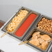 A Cambro amber plastic food pan on a table with food in it.