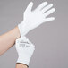 A person's hands putting on white Cordova Halo gloves.