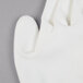 A close up of a Cordova Javelin white warehouse glove with white Polyurethane palm coating on a gray surface.