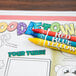 A group of kids crayons on a Hoffmaster Doodletown placemat with the words "Doodletown" and a drawing of a town.