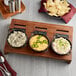 A Valor pre-seasoned mini cast iron casserole dish on a table with bowls of dips and chips.