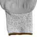 A close up of a large gray and white Cordova warehouse glove with a brown trim.