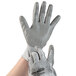 A pair of hands wearing Cordova grey and silver warehouse gloves.