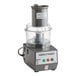 A Robot Coupe commercial food processor with a clear container and white lid.