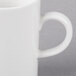 A close-up of a Villeroy & Boch white porcelain coffee mug with a handle.