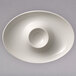 A white oval porcelain bowl with a round hole in the middle.