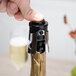A person using a Franmara plastic champagne bottle stopper to seal a bottle of champagne.