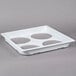 A white plastic tray with four circles.