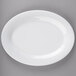 A white Carlisle oval melamine platter with a white rim on a gray surface.