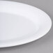 A close-up of a white Carlisle oval melamine platter with a white rim.