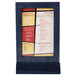 A Menu Solutions wood table tent with a denim frame holding a white menu with black text.