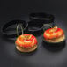 A round pastry with orange glaze and a sprig of fruit in a Matfer Bourgeat tartlet ring.
