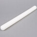 A white cylindrical plastic rolling pin on a gray surface.