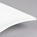 A CAC Miami bone white porcelain square plate on a gray surface.