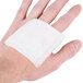 A hand with a Medi-First gauze pad on it.