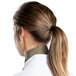 A woman with a ponytail wearing a beige Intedge chef neckerchief.