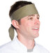 A man wearing a beige chef neckerchief with a chef hat.