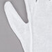 A close-up of a Cordova white cotton inspection glove.