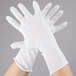 A pair of hands wearing white Cordova inspection gloves.
