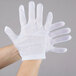 A close-up of a person wearing a white Cordova inspector glove.