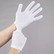 A person wearing white Cordova Men's Nylon Inspector's Gloves.