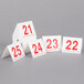 A stack of Cal-Mil white and red double-sided number table tents with red numbers on white cards.