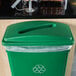 A Lavex green slim rectangular recycling trash can lid on a green recycling bin.