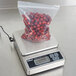 An Edlund Resolution RGS-600 precision gram scale weighing a bag of red berries.