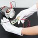 A person wearing Cordova white inspector's gloves holding a circuit board.