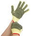 A close-up of a gloved hand wearing Cordova heavy duty work gloves with PVC dotted coating.