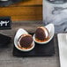 A pair of brown and white desserts on Acopa matte black stoneware plates.